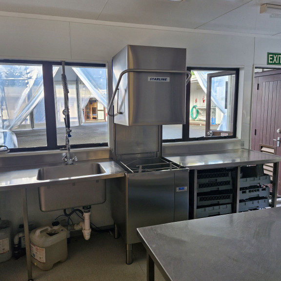 The kitchen dishes area with commercial dishwasher