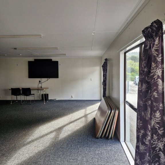 The Stuart Room with a large 75" Smart TV, carpet and heat pumps