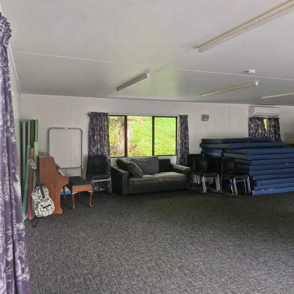 The Stuart Room with musical instruments, a couch, carpet, heat pumps and extra mattresses